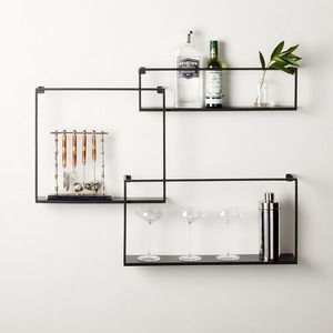 black floating shelves on a wall with barware on it